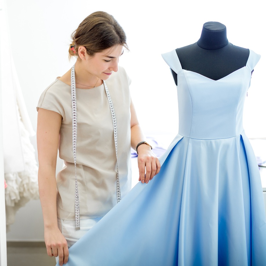 pretty-young-girl-adjusts-dress-mannequin-blue-dress-mannequin-seamstress-sewing-workshop